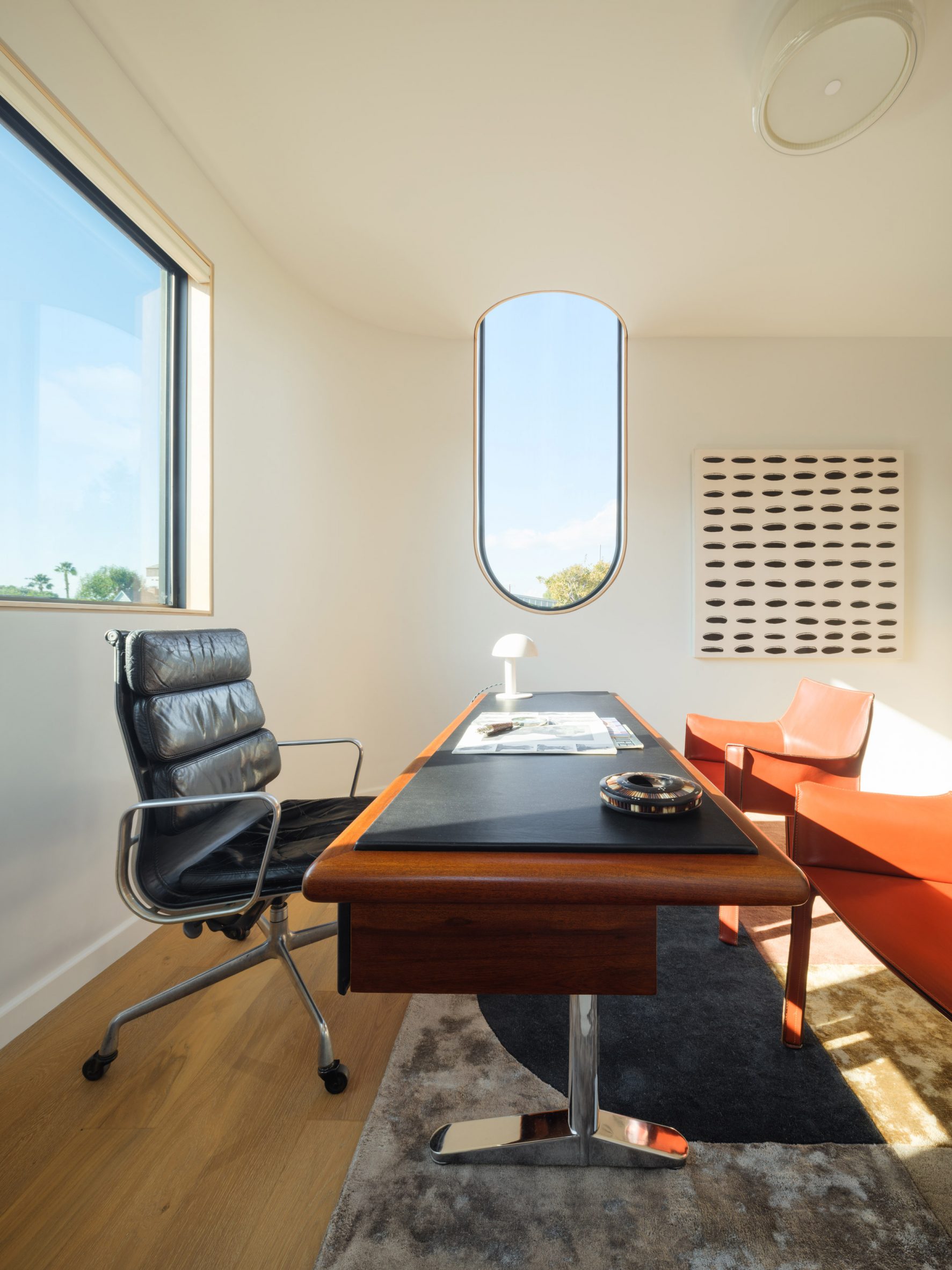 Upstairs office and bedroom in the Offset ADU, with a tall U-shaped window extending into a mirrored cove.