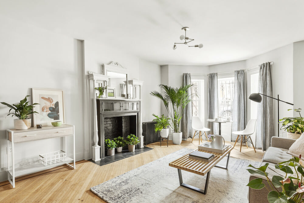 Renovated garden-level brownstone apartment with pale walls and a bright rear window wall