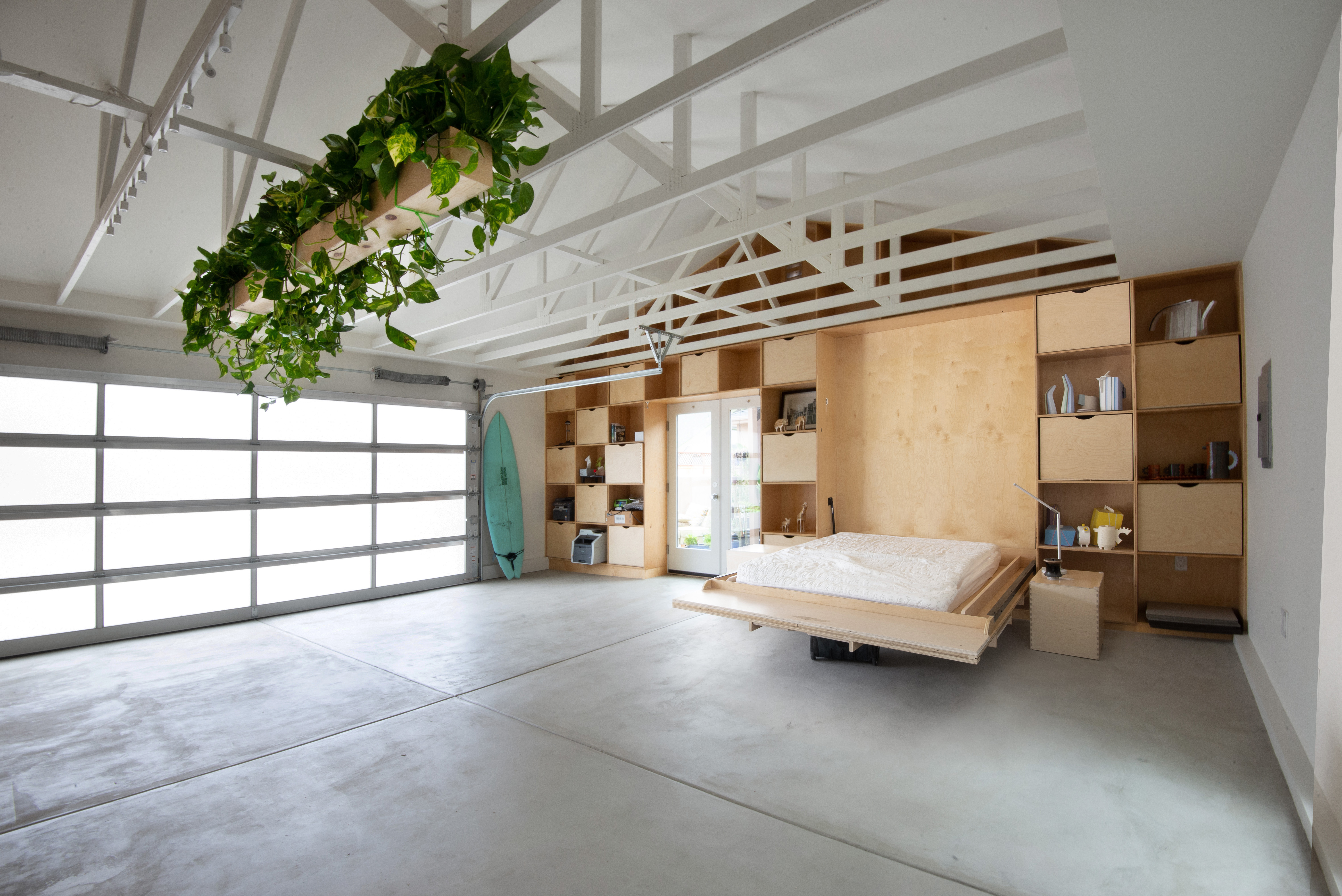 Interior of a garage converted into an ADU with a wall bed and flexible furniture