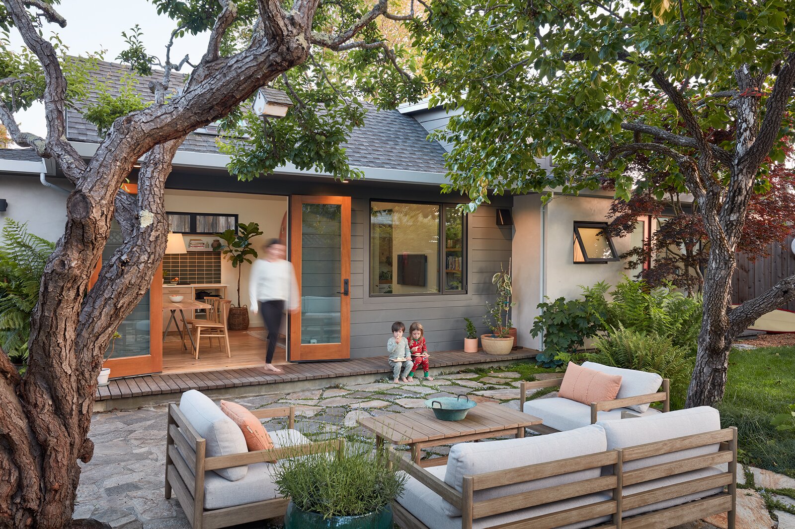 Two young children play in the backyard of a California accessory dwelling unit shared by three generations of one family