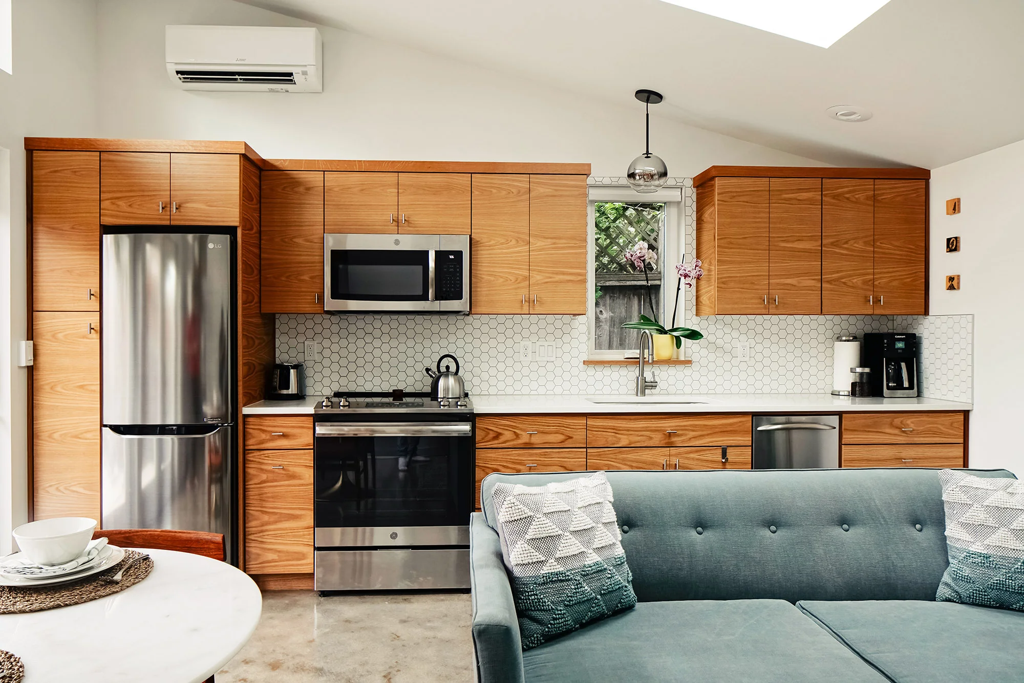 Interior kitchen of the Wedge ADU with natural wood cabinetry against a polished concrete floor