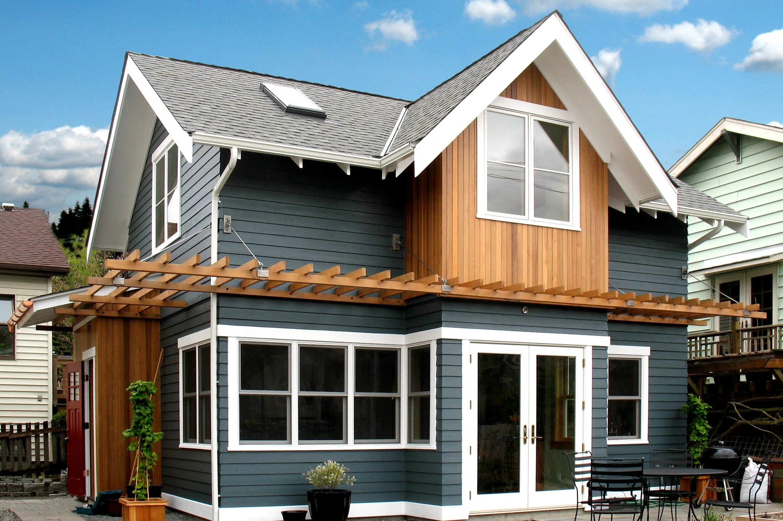 A detached backyard cottage in Seattle with wood siding and large windows