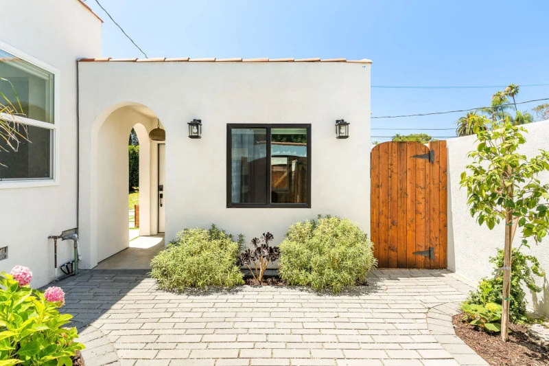 A converted garage ADU with a kitchen and living area in a Spanish-style bungalow