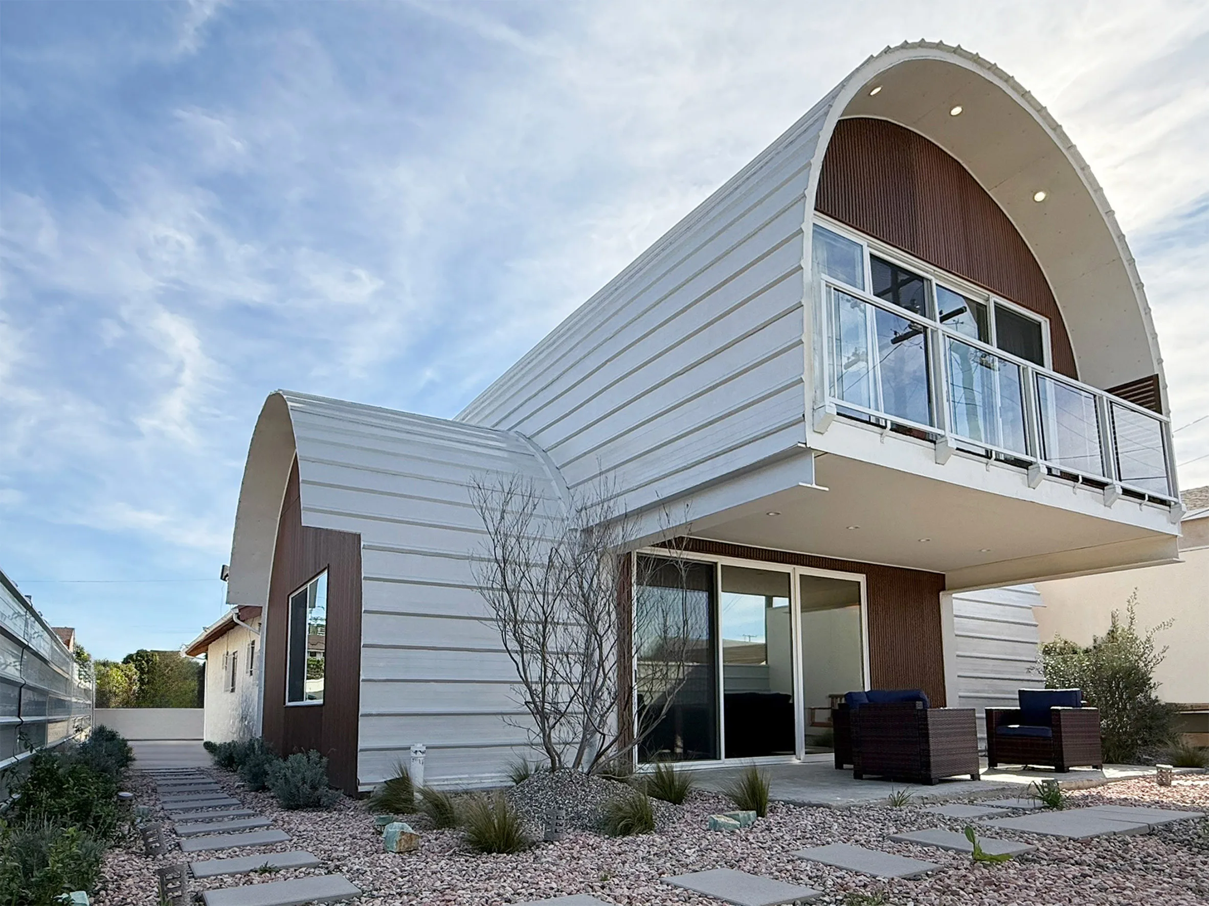 Two arched white steel ADU volumes stacked at a right angle on a Los Angeles lot