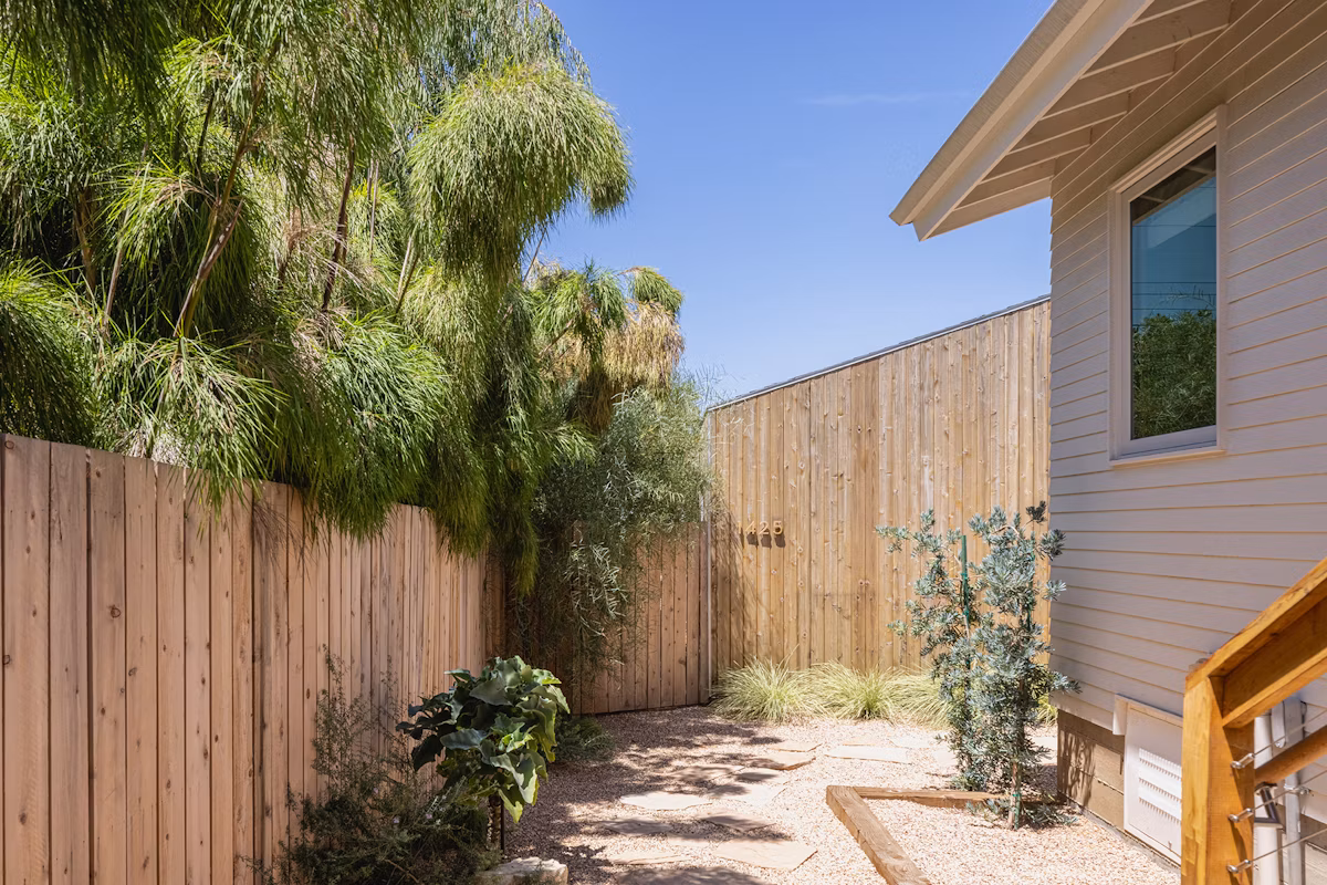 A gravel and flagstone path leads to the cedar-clad standalone ADU at the rear of the lot